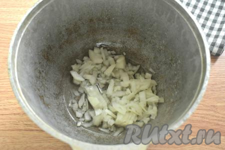 Я готовила ленивые голубцы в казане, вы можете использовать глубокую сковороду или сотейник. Очищаем лук и морковь. Наливаем в казан растительное масло и хорошо его разогреваем. Если в тушёнке много жира, тогда можно использовать этот жир вместо масла. В разогревшееся масло (или жир) выкладываем мелко нарезанный лук.