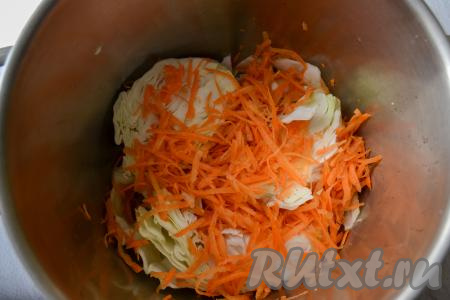 Морковь очистите и натрите на крупной тёрке. Выложите часть натёртой морковки поверх капусты.