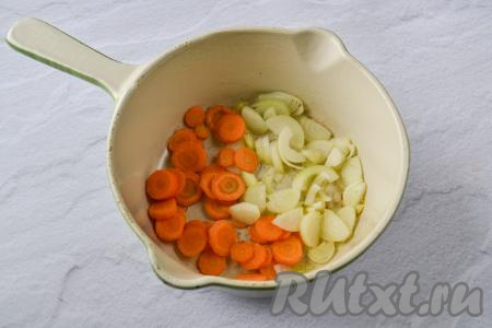 Кабачок и тыкву очистите от кожуры. Из тыквы удалите семечки с волокнами. Если у кабачка крупные семена, тогда их тоже нужно удалить. Морковь, чеснок и лук очистите. Зелень вымойте. Разогрейте в сотейнике (или в сковороде) растительное масло, выложите морковь, нарезанную на тонкие кружочки (или полукружочки) и лук, нарезанный на полукольца (или четверть кольца), перемешайте.