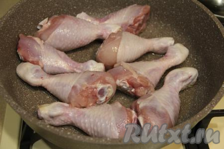 В сковороду влить растительное масло, прогреть его, затем выложить куриные ножки в один слой.