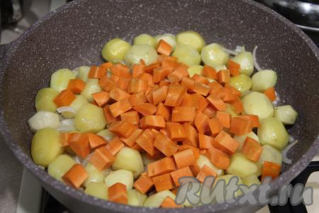 Морковь очистить, нарезать на небольшие кубики, добавить в сковороду, перемешать, обжаривать овощи минут 5, не забывая их иногда аккуратно перемешивать.