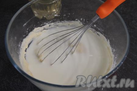 Влить растительное масло и 200 миллилитров молока комнатной температуры, перемешать дрожжевое блинное тесто.