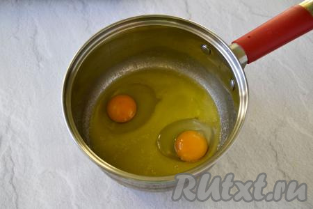 Когда масло немного остынет, добавьте в него сырые яйца. Не добавляйте яйца в горячее масло, иначе белок в яйцах может свернуться.