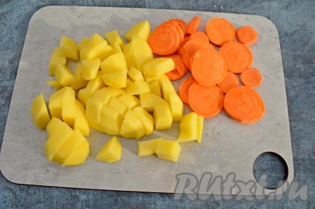 Очистить картофель и морковь. Картошку нарезать на средние кубики, морковку - на кружочки.