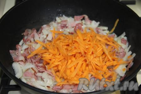 Обжарить лук с беконом минут 5, время от времени помешивая, а затем добавить морковь, натёртую на крупной тёрке.