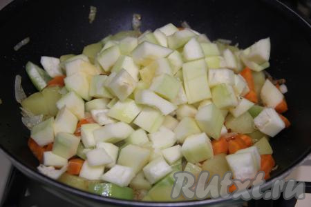 Сразу же добавить 300 грамм подготовленного кабачка, нарезанного на кубики 1,5 на 1,5 сантиметра, перемешать и обжаривать овощи 5 минут, не забывая их изредка перемешивать.