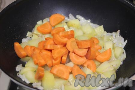 К картошке, обжаренной с луком, добавить морковь, нарезанную на полукружочки (или кружочки), перемешать, обжаривать овощи минут 5, иногда перемешивая.