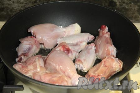 В сковороду влить растительное масло, разогреть его и выложить кусочки курицы.