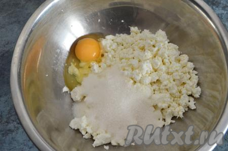 В глубокую миску всыпать творог и сахар, вбить сырое яйцо.