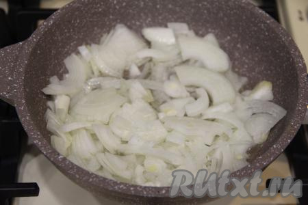 В сковороде хорошо разогреть растительное масло, затем выложить в него лук, нарезанный на полукольца.