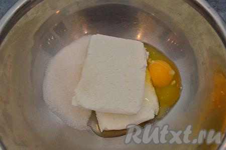В глубокую миску выложить творог, вбить сырое яйцо и всыпать сахар.