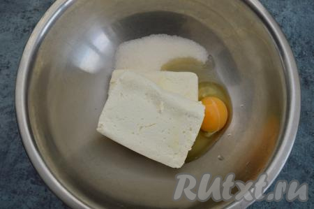 Когда изюм будет подготовлен, можно приступать к приготовлению сырников, для этого в достаточно объёмную миску нужно всыпать сахар, вбить яйцо, выложить творог.