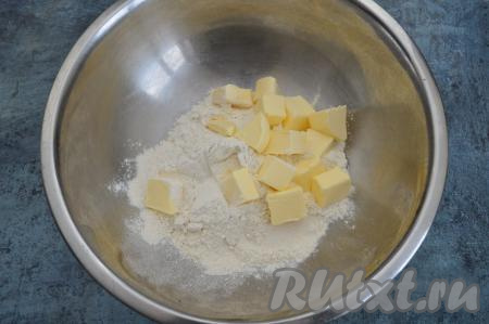 Для замешивания песочного теста нужно в миску всыпать муку, сахар и щепотку соли, добавить холодное сливочное масло, нарезанное на кубики.