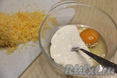 Для получения заливки соединить в миске сметану и сырые яйца, перемешать вилкой. Сыр натереть на крупной тёрке.