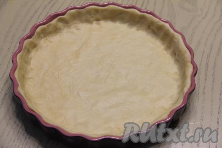 Достать песочное тесто из холодильника. В форму для выпечки (у меня - форма диаметром 25 сантиметров) выложить тесто, распределив его по дну и бортикам формы.