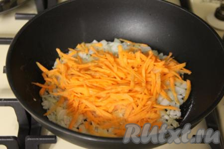 К обжаренному луку выложить очищенную и натёртую на крупной тёрке морковку, сразу перемешать овощи и обжаривать их, периодически перемешивая, минут 5 (до мягкости моркови).