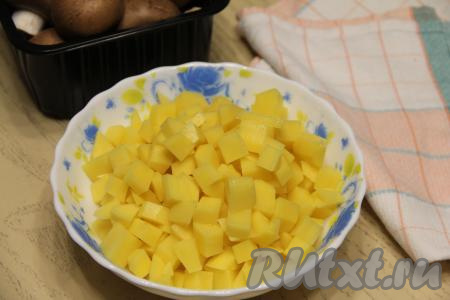 Пока тесто охлаждается в форме для выпечки, подготовим картофельно-грибную начинку для киша. Для этого очищенную картошку нужно нарезать на кубики размером примерно 1 сантиметр на 1 сантиметр.