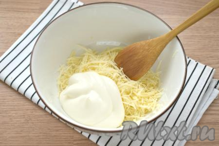 Твёрдый сыр натираем на крупной тёрке в глубокую тарелку, добавляем к нему майонез и перемешиваем.