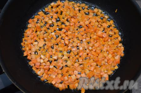 В сковороде разогреть на среднем огне сливочное масло, выложить нарезанную морковь и обжарить её, периодически помешивая, до мягкости (в течение 5-7 минут).