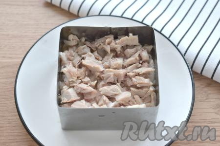 Следующим слоем выкладываем куриное мясо, нарезанное на небольшие кубики.