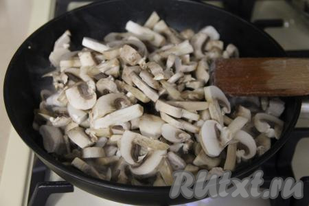 Шампиньоны промыть и нарезать на тонкие ломтики. Добавить грибы в сковороду к обжаренной курице.