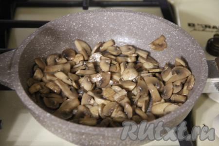 В сковороде разогреть растительное масло, затем выложить шампиньона и обжарить грибы на среднем огне в течение 15-20 минут, иногда помешивая.