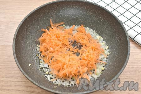 Морковь натираем на крупной тёрке, выкладываем к луку, обжаренному с чесноком, перемешиваем. Жарим овощи 3-4 минуты (до мягкости морковки), периодически перемешиваем.