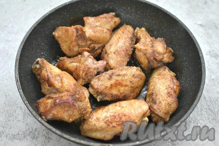 Разогреваем на сковороде растительное масло. Выкладываем в горячее масло куриные крылышки в соевом соусе и на огне выше среднего обжариваем их по 3 минуты с каждой стороны.