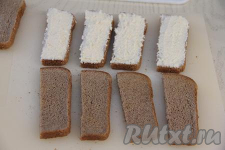 Кусочки чёрного хлеба предварительно подсушить в тостере или с двух сторон на сухой сковороде. Подсушенные кусочки хлеба нарезать в длину на 2 части (у нас получатся 10 кусочков хлеба). Смазать кусочки хлеба смесью, приготовленной из яиц, плавленного сырка и майонеза.