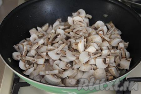 Шампиньоны промыть водой, нарезать на пластинки. Добавить грибы в сковороду с обжаренным куриным мясом.