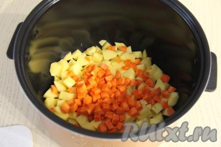 Морковь нарезать на небольшие кубики. В чашу мультиварки (у меня - мультиварка Редмонд) выложить нарезанные картошку и морковь.