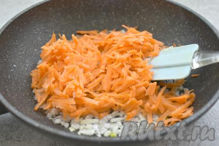 К обжаренному луку выкладываем очищенную и натёртую на крупной тёрке морковь, перемешиваем. Обжариваем овощи 4-5 минут (до мягкости морковки), периодически помешивая. Обжаренные овощи убираем с огня.