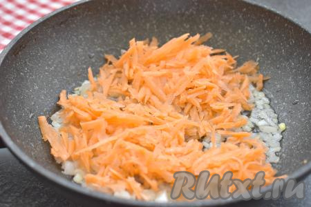 К обжаренному луку выкладываем натёртую на крупной тёрке морковь, перемешиваем. Обжариваем овощи до мягкости моркови (в течение 5-6 минут), не забывая иногда перемешивать.