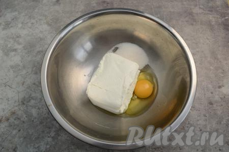 В глубокую миску выложить обезжиренный творог, сахар и сырое яйцо.