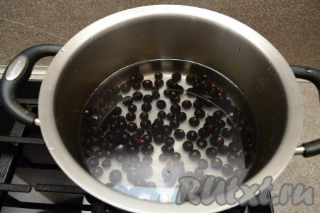 В кастрюлю с замороженными ягодами чёрной смородины и сахаром влить 1 литр холодной воды, перемешать и поставить на сильный огонь.