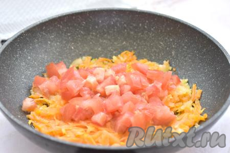 После того как морковка станет мягкой, добавляем в сковороду вымытый и нарезанный на небольшие кубики помидор, перемешиваем овощи.