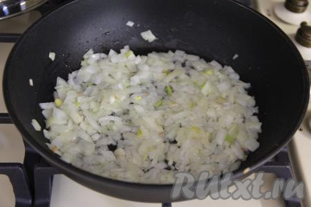 Почистить морковку и лук. Рис промыть водой, дать лишней воде стечь. В сковороде хорошо прогреть растительное масло, выложить мелко нарезанный лук, обжарить его, иногда помешивая, до прозрачности (в течение 5 минут) на среднем огне.