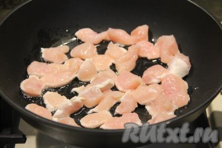 В сковороду влить растительное масло, прогреть его, выложить кусочки куриного филе.