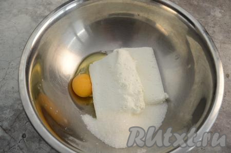 В миску вбить сырое яйцо, выложить творог, всыпать сахар.