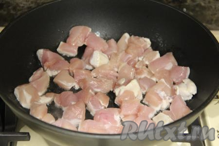 Для этого блюда я взяла филе куриной грудки, также можно взять филе бедра курицы. Мясо вымыть, обсушить, нарезать на кубики размером 1,5 сантиметра на 1,5 сантиметра. В сковороде разогреть растительное масло, затем выложить кусочки мяса курицы.