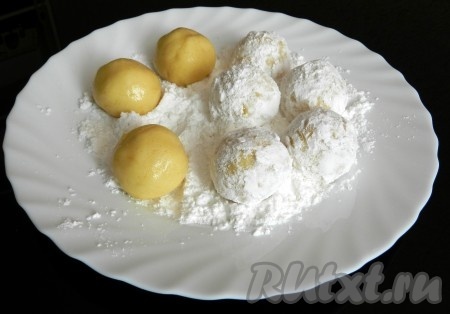 В тарелку насыпать сахарную пудру. Из теста скатать шарики и хорошо прокатать их в сахарной пудре.
