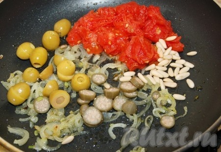 К обжаренному луку добавить помидоры, оливки, каперсы и орешки пинии.
