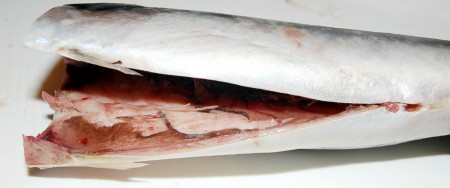 Выпотрошить внутренности и чёрную плёночку из брюшка каждой рыбки, голову и плавники отрезать.

