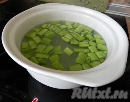 Отварить фасоль в кипящей подсоленной воде 5 минут. Добавить зеленый горошек, поварить еще 3 минуты. И откинуть на дуршлаг.