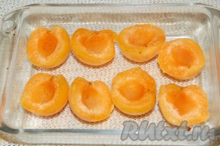 Абрикосы переложить в огнеупорную форму. В каждую половинку абрикоса положить по капельке меда.
