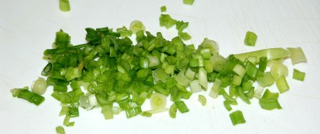 Нарезать мелкими кусочками зеленый лук.