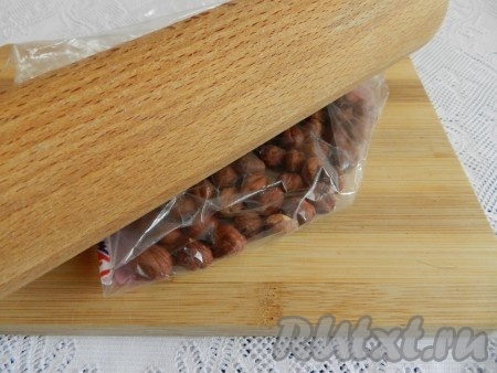 Фундук сложить в пакет и слегка раздавить скалкой, чтобы кусочки орехов были крупными.