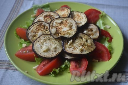 На помидоры выложить обжаренные баклажаны. Посыпать салат рубленным чесноком.
