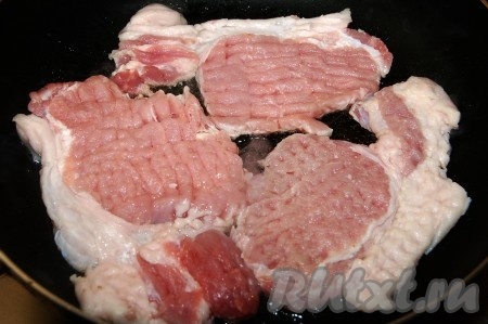 На сковороду налить растительное масло, раскалить его и положить жариться отбивные из свинины.