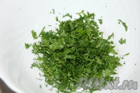 Зеленый лук мелко нарезать и добавить в миску к кинзе.